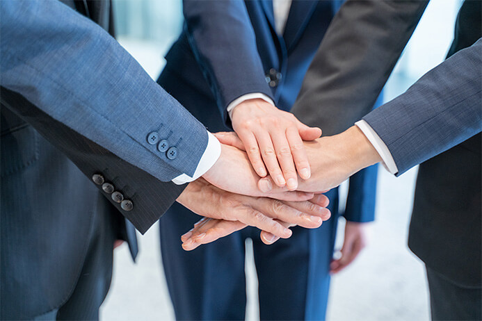 社員が一つになり手を重ねている手元